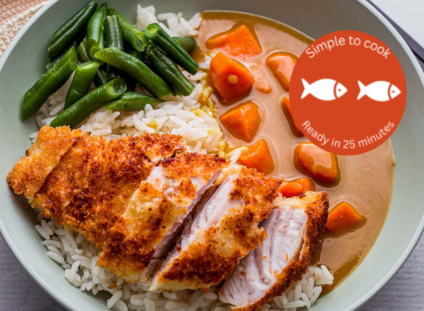 A crumbed piece of fish in a green bowl, with rice, beans and carrots in a brown sauce.